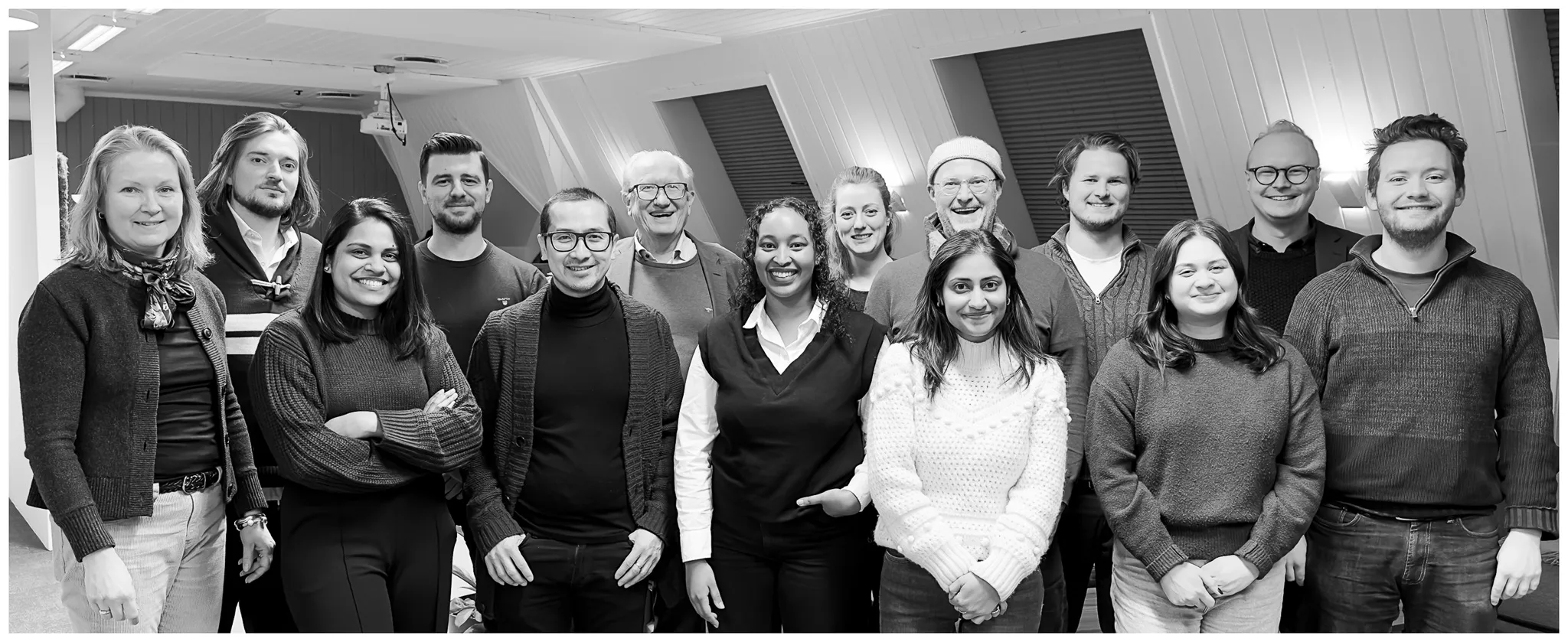 Group photo of the Compose Software team standing together in an office setting, smiling and facing the camera.